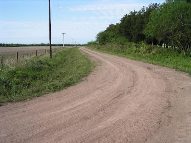 the dirt road parallel to the highway, seen towards North