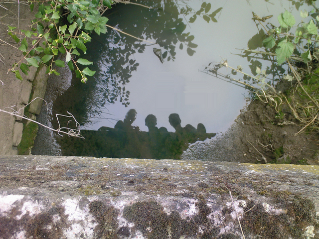 Corine, Adriaan and Bert reflected in a small river. (From a bridge)