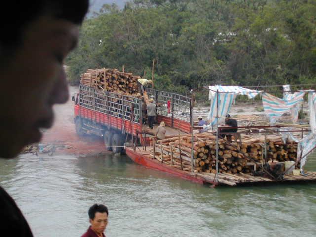 Log barge off loading onto a cargo truck