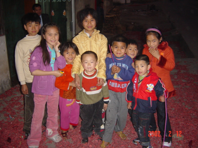Children surrounded by the debris of spent firecrackers