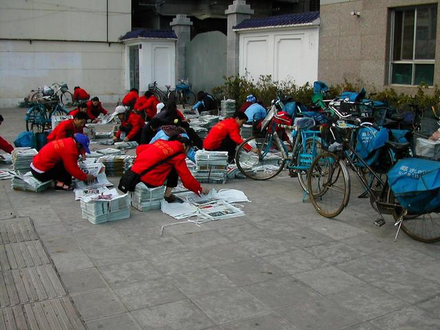 Kunming Newspaper carriers assembling the newspapers before delivery