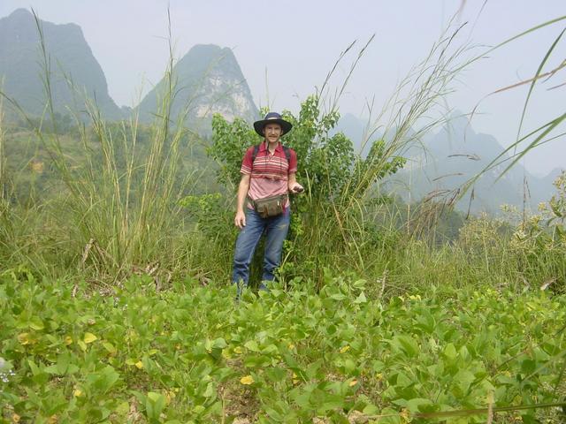 Targ standing on the confluence point, with huangdou (soya beans) in the foreground and karst mountains behind