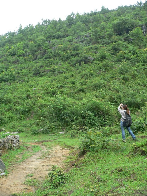 Ah Feng standing near the good path, taking a photo of the slope on which the confluence is located.