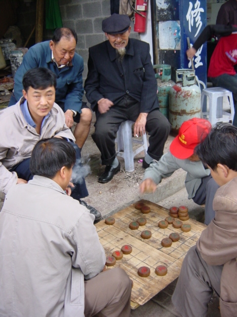 Action scene from the ubiquitous pavement Chinese chess match
