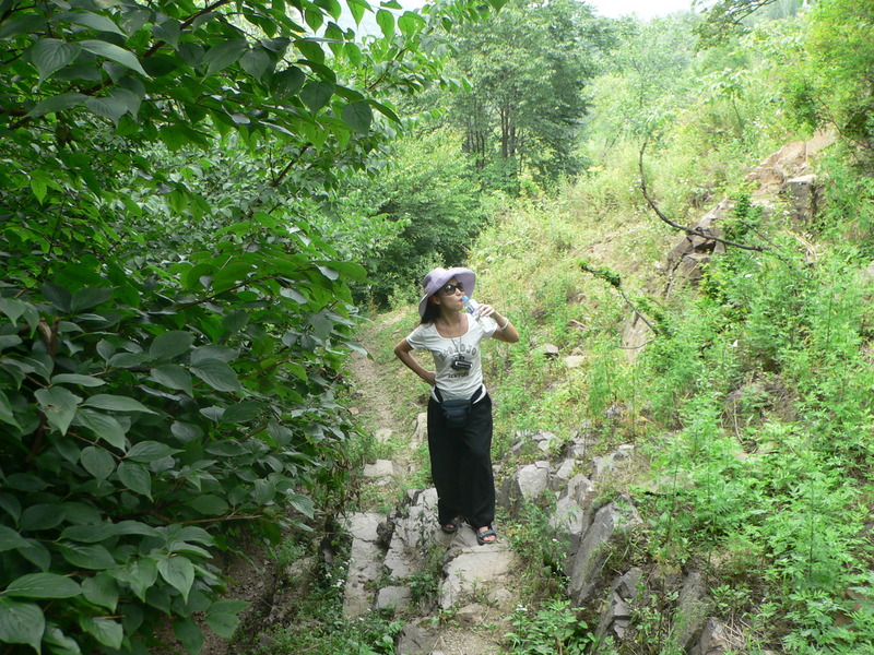 Ah Feng pauses for a sip of water on the path up into the hills