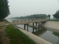 #3: Ah Feng crossing a canal, 1 km from the confluence