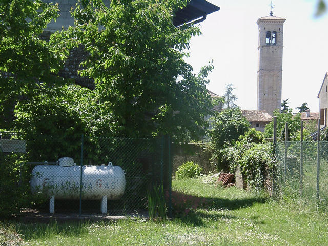 The confluence point is at the corner of the house, behind the gas tank (seen from the east). Background: church of San Lorenzo