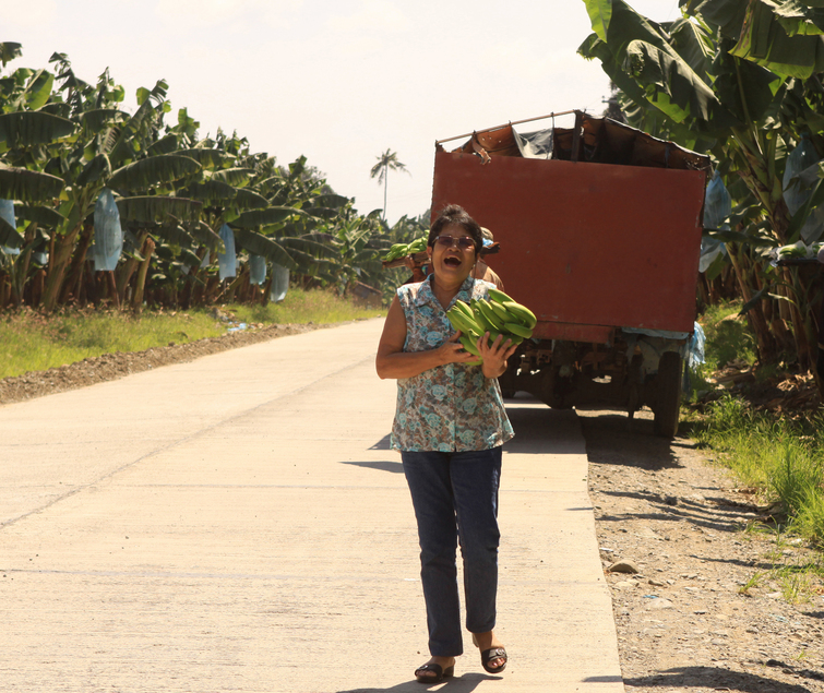 Santah with a bunch of Cavendish given by man harvesting banana  at Sto. Tomas, Davao del Norte 