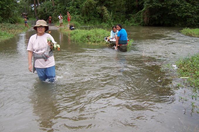 Santah never missed the chance to pick flowers while wading through the flooded road. Flood is a washing opportunity for two residents.