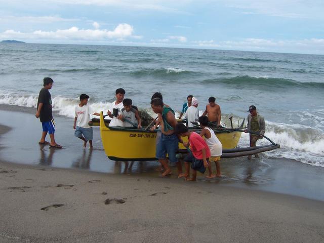 All hands on deck to lift newly landed boat to escape the next wave