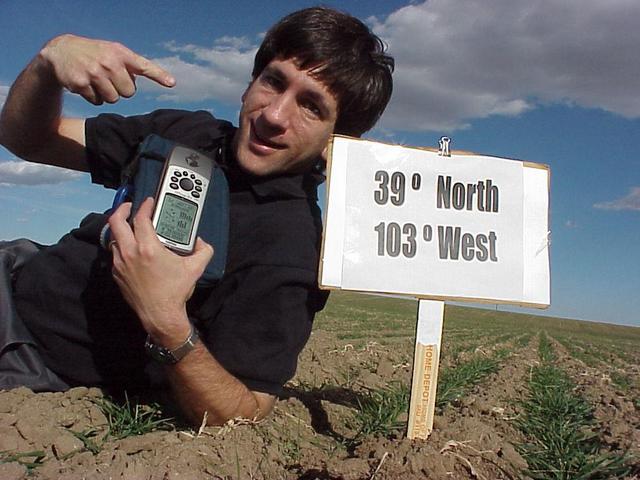 Joseph Kerski, lying in the field, at the confluence site.