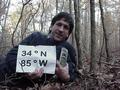 #3: Joseph Kerski at 34 North 85 West, lying in a Georgia forest.