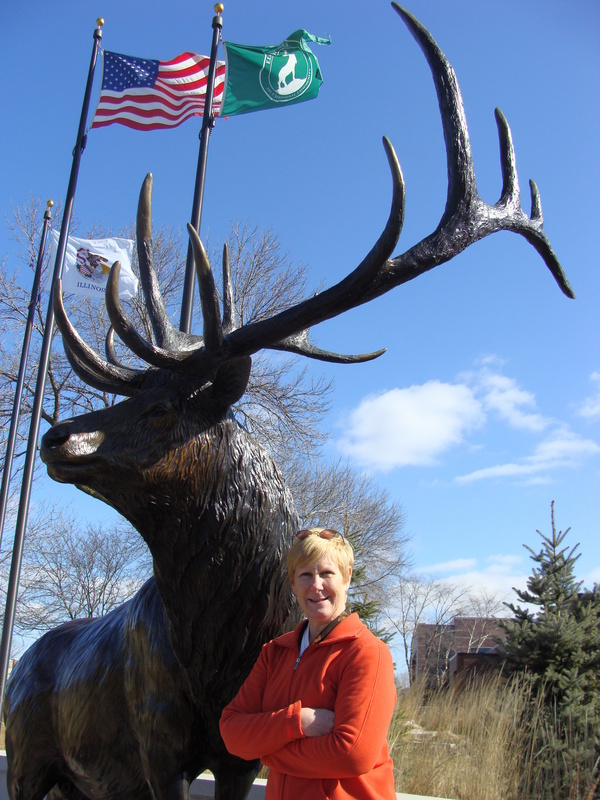 Cynthia poses at the namesake of Elk Grove Village