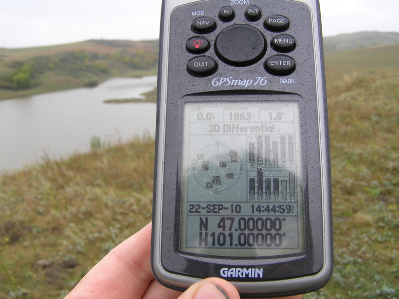 Wet GPS at the confluence point with the reservoir in the background.