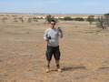 #7: Picture of me standing at the Confluence Point with the dam in the left background