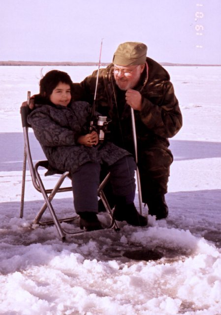 A girl and her grandfather, ice fishing.