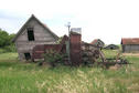 #9: Outbuildings and machinery on the homestead. Note the wild roses growing around the machinery.