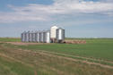 #8: Grain bins and hay bales with sprinkler system in background.