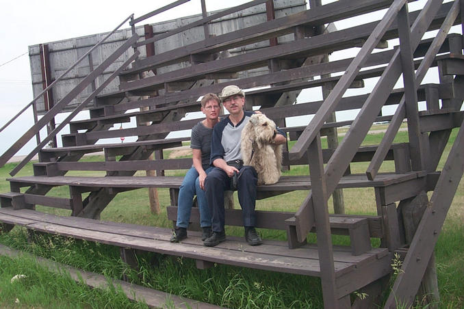 Carolyn, Alan and Max on the bleachers on the Vanscoy rodeo grounds.
