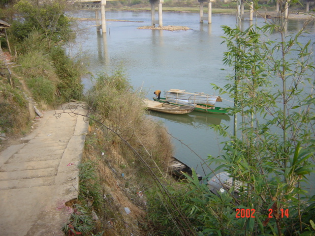The boat serving as the only means of river crossing until the bridge in the background is completed