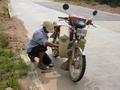 #2: Motorcyclist repairing bike in hot sun