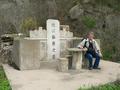 #7: Jim sitting at the picnic table in front of a Chinese grave