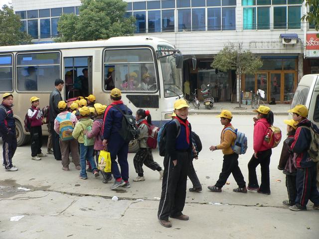 Schoolchildren queuing up to board bus in Hongqiao
