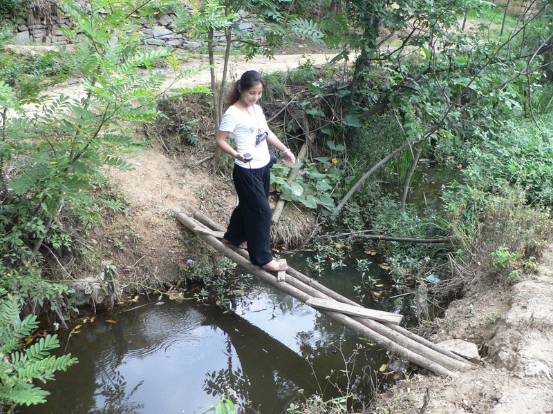 Ah Feng crossing the stream on a tiny bridge