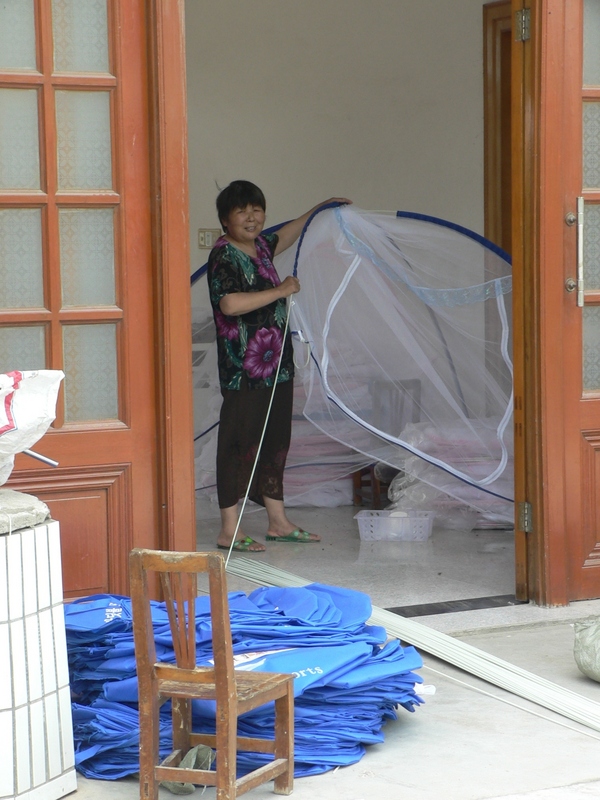 Local resident making mosquito nets in her home