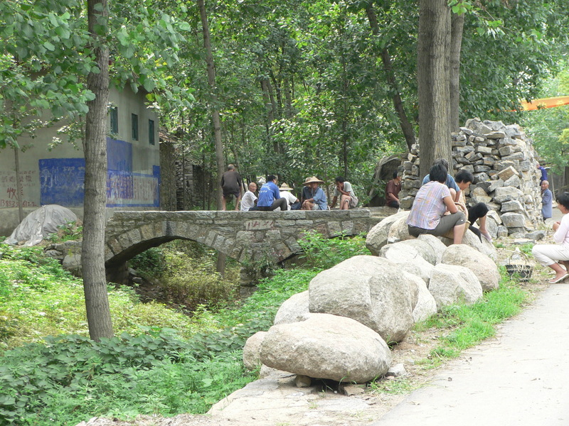 Stone arch bridge, and more stones piled up beside the road