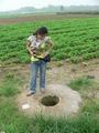 #2: Ah Feng looking down a well in the middle of the fields