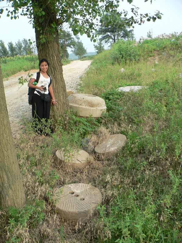 Ah Feng and some abandoned millstones beside the road leading to the confluence