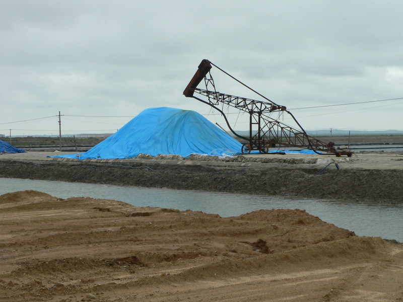 Mound of salt covered in a blue tarpaulin