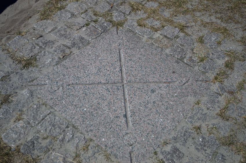 The confluence point is marked by a cross in a concrete slab