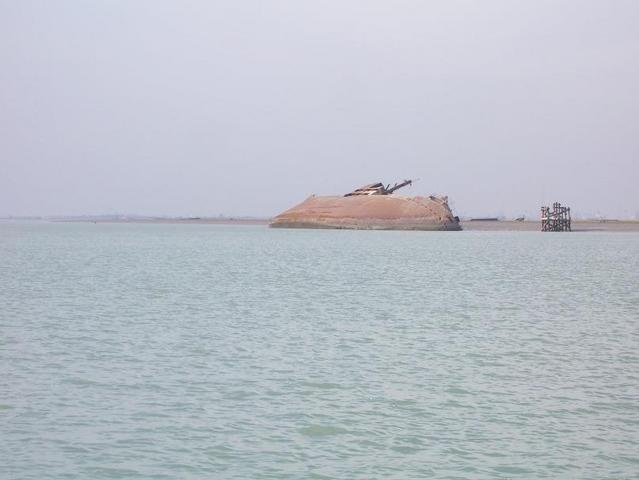 Looking west from 30N 48E, another ship wreck is in front of al-Fāw peninsula, Umm Qasr is on the distant horizon