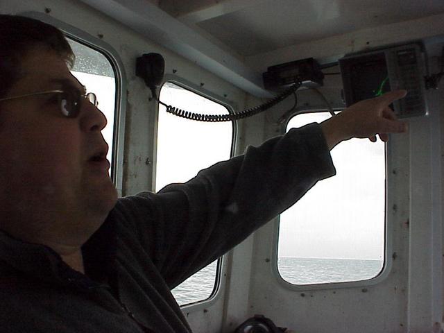Dave Turner, commercial fisherman and captain of the Sarah Louisa, points out some of the electronic features of the boat.