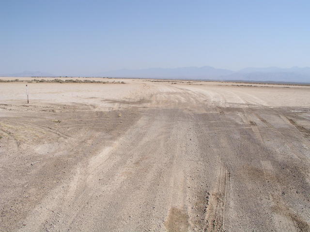 A mile north of 36N 116W, the nearby road crosses a dry lakebed.