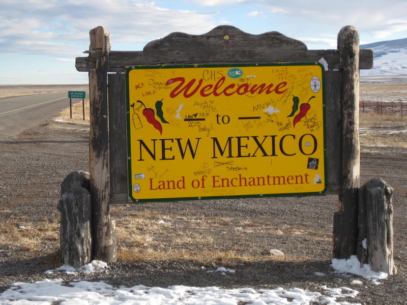 Looking south at the New Mexico welcome sign, and the actual state line sign behind it