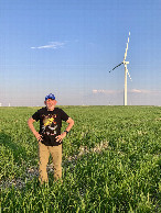 #8: Tiny moon almost eclipsed by wind turbine blade at 41°N 103°W.