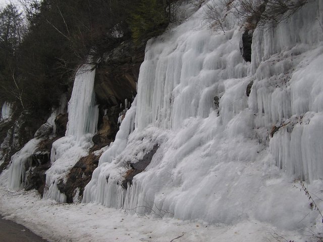 Stalactites of ice flowing from roadside ledges