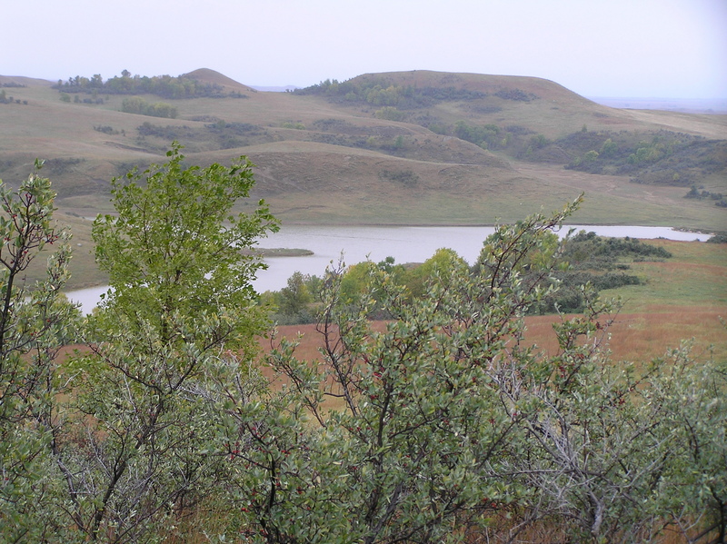 View of the confluence from 500 meters to the northwest, looking southeast.  The confluence is on the far side of the reservoir, on top of the first bluf in center-right.