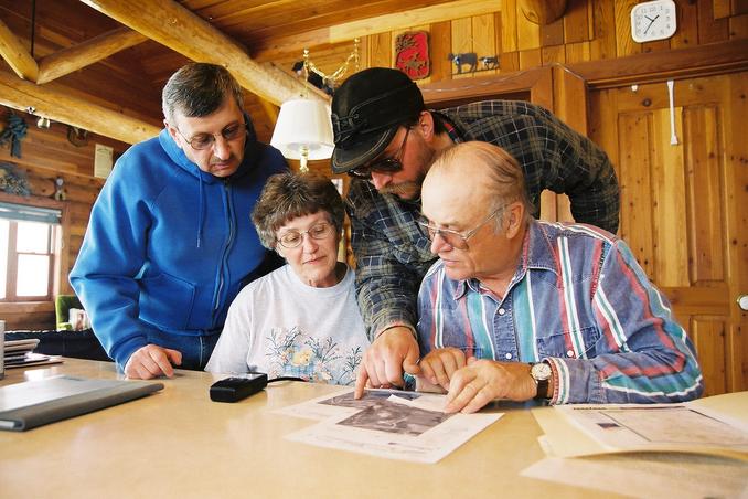 Reviewing maps and photos. From left are George Ding and Gladys, Brent and Florian Woroniecki.