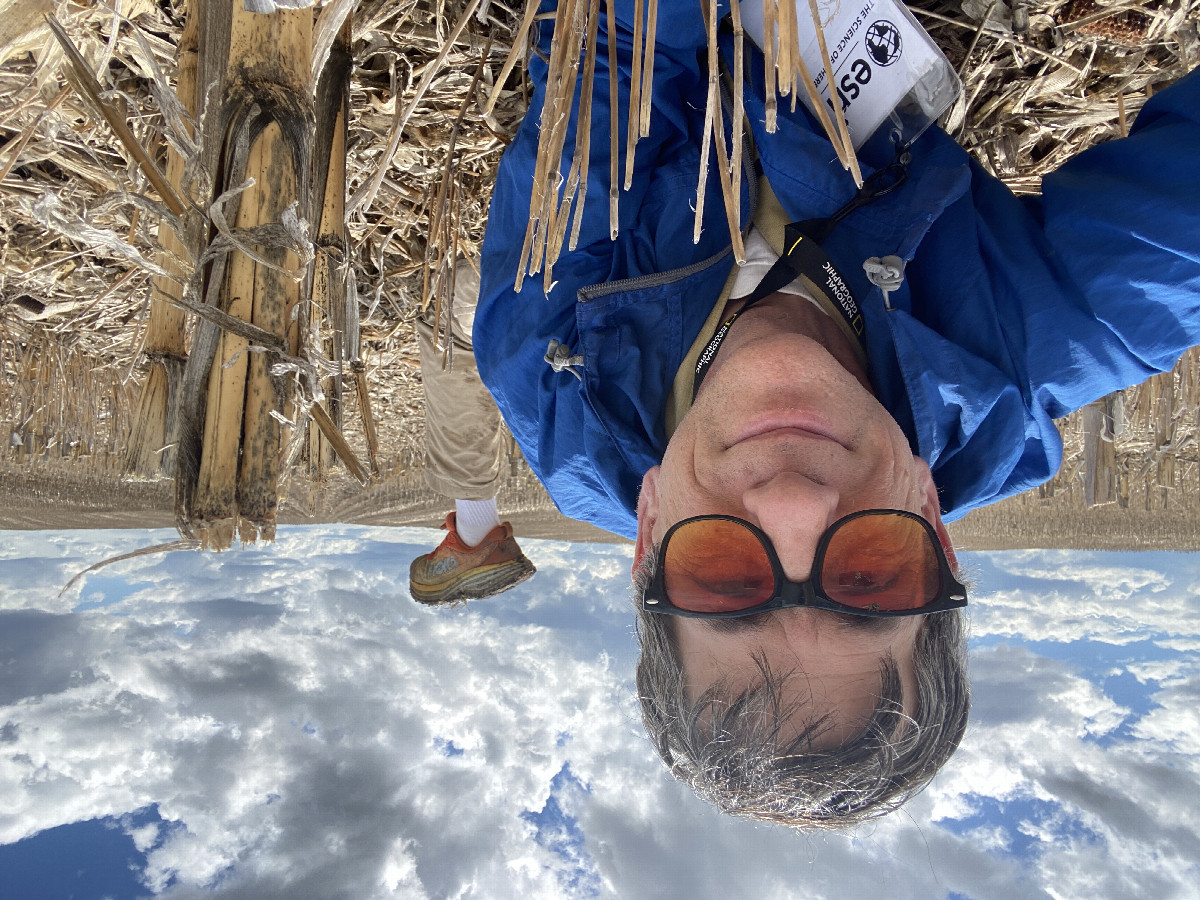 Joseph Kerski lying in field at confluence point. 