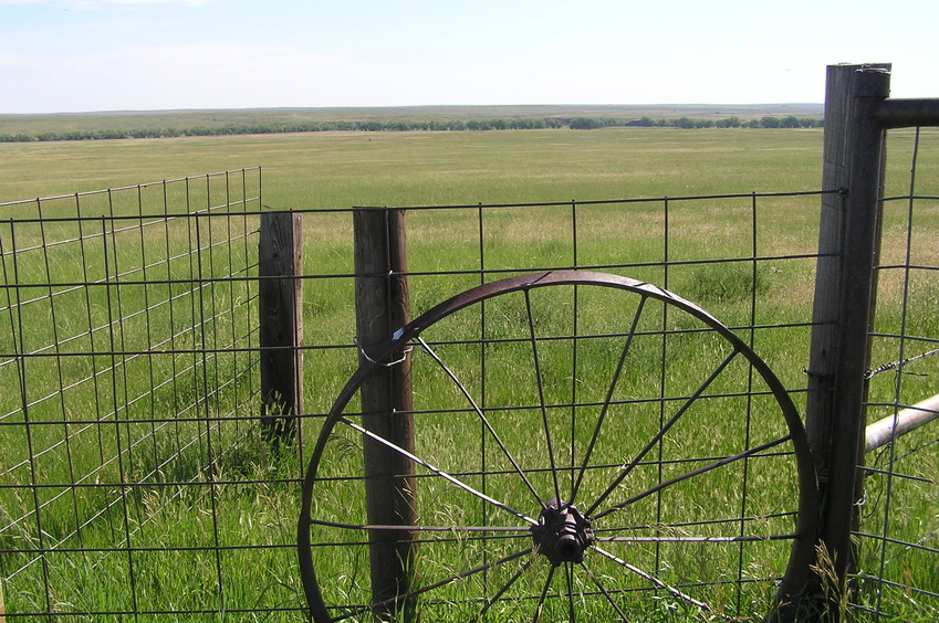 Fence and wagon wheel, about 150 meters south-southwest of the confluence, looking east-northeast.
