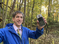 #7: Joseph Kerski wearing map tie in the forest at the confluence point. 