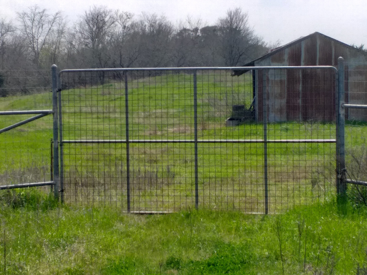 Large gate and fence to be crossed to get back on the road
