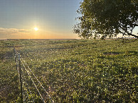 #9: The confluence lies in the far distance, under and to the right of the sun, in the flat part of the terrain.