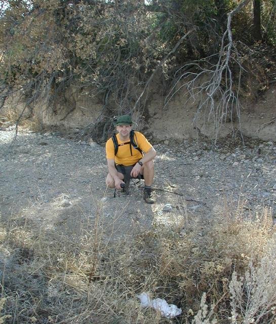 Jim in the dry stream bed; snow in the foreground
